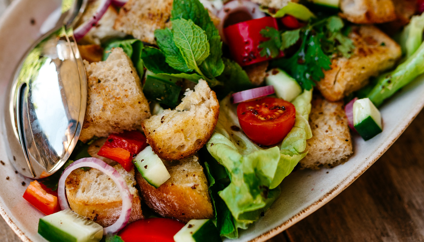 Frischer Brotsalat mit Tomaten, Gurken, Paprika, Zwiebeln, Kräutern und gerösteten Brotwürfeln.