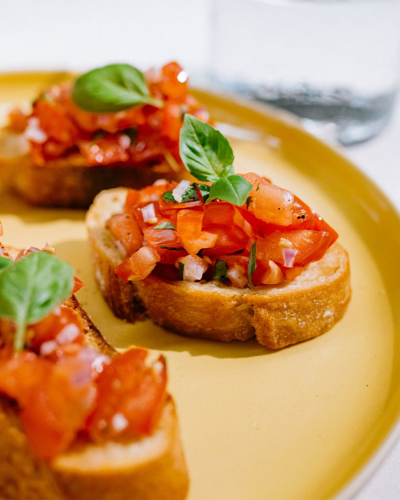 Drei Bruschetta-Variationen mit erlesenen Zutaten und Brot von Morgengold auf den Teller: Bruschetta con pomodoro